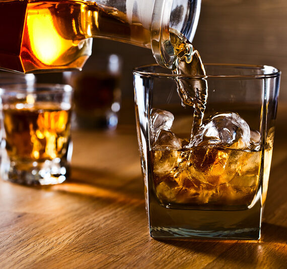 pouring whiskey over ice image